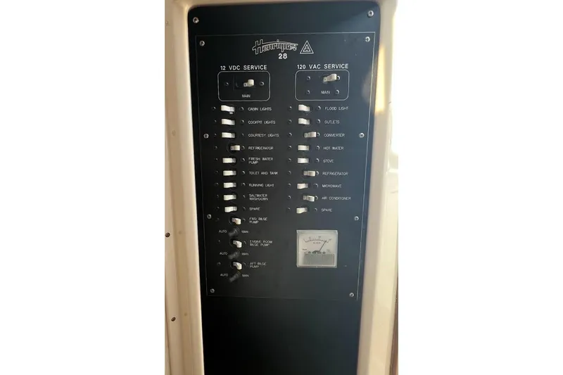 Slide: The Image of Electrical panel of a 1998 Henriques 28 Express boat, showing 12V and 120V service switches. - 8