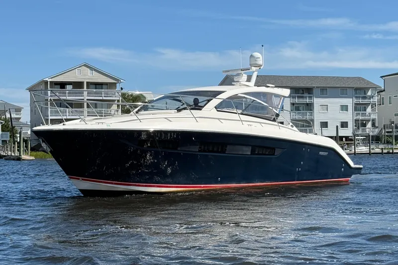 The Image of 2013 Pursuit SC 365i Sport Coupe yacht cruising near waterfront homes. - 1
