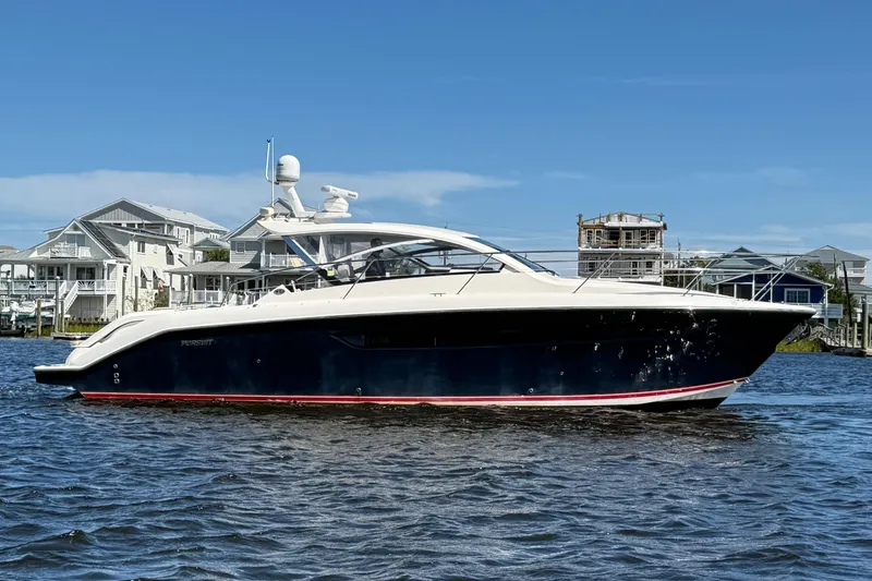 Slide: The Image of 2013 Pursuit SC 365i Sport Coupe yacht on water, with coastal homes in background. - 5