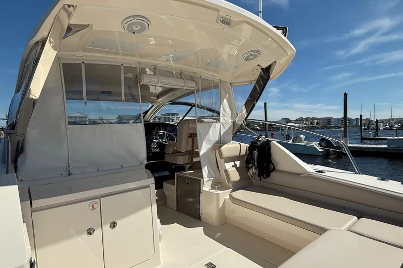 Slide: The Image of 2013 Pursuit SC 365i Sport Coupe interior with seating, docked at marina under clear sky. - 7