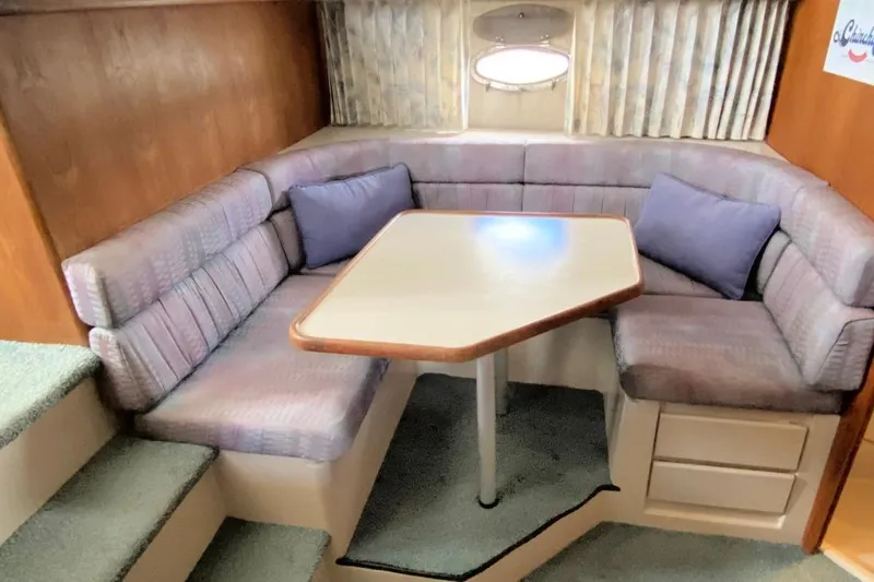 Slide: The Image of 1992 Carver 36 Aft Cabin interior with cozy dining area and cushioned seating. - 17