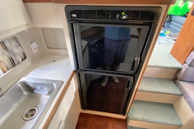 Slide: The Image of 1992 Carver 36 Aft Cabin kitchen with sink, refrigerator, and stairs. - 20