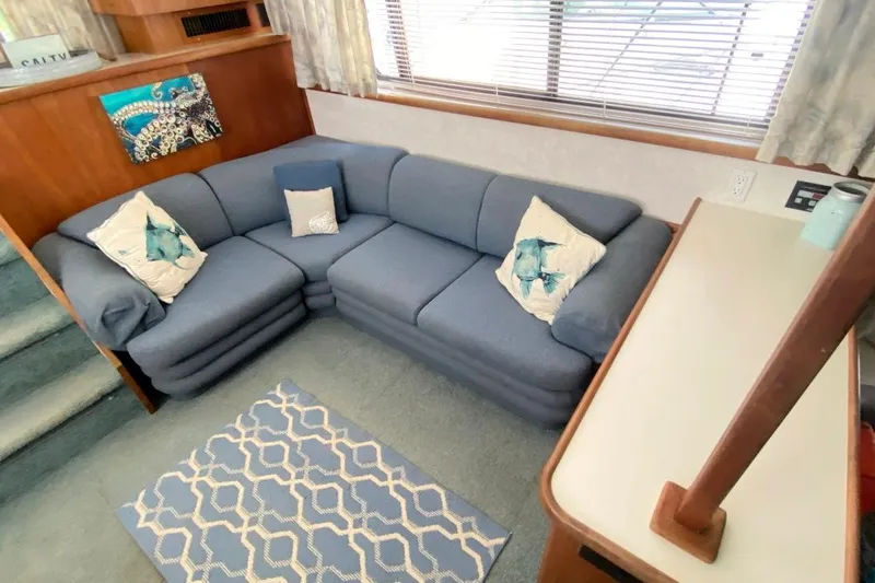 Slide: The Image of 1992 Carver 36 Aft Cabin interior with blue sectional sofa and nautical decor. - 23