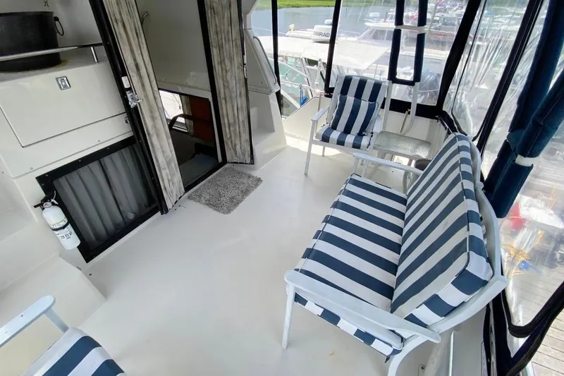 Slide: The Image of 1992 Carver 36 Aft Cabin interior with striped seating and open cabin door. - 6