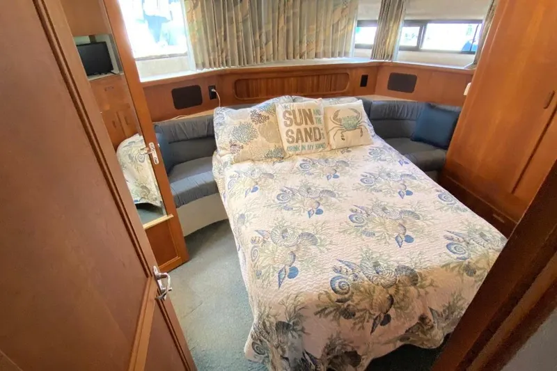 Slide: The Image of Cozy 1992 Carver 36 Aft Cabin bedroom with floral bedding and decorative pillows. - 12