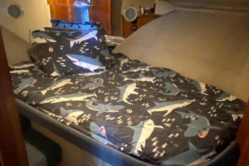 Slide: The Image of 1992 Carver 36 Aft Cabin bedroom with shark-themed bedding and cozy interior. - 18