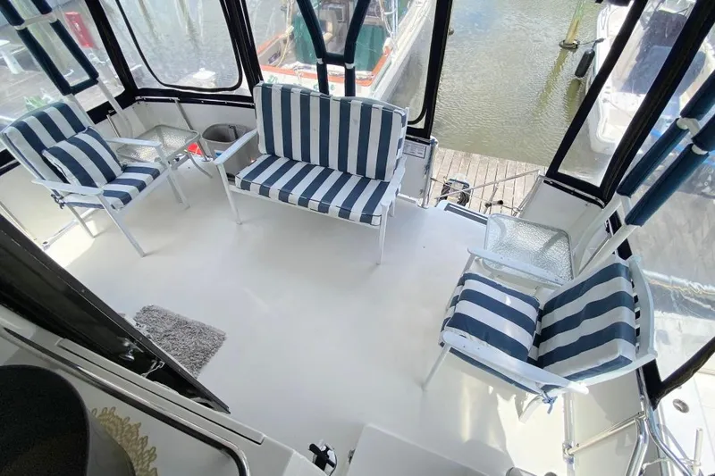 Slide: The Image of 1992 Carver 36 Aft Cabin boat interior with striped seating and marina view. - 3