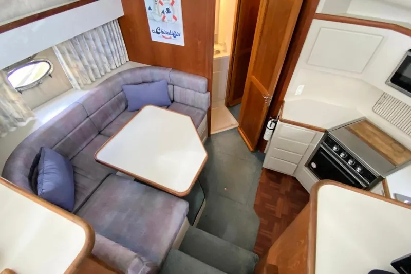 Slide: The Image of Interior of 1992 Carver 36 Aft Cabin with cozy seating and compact kitchen. - 4