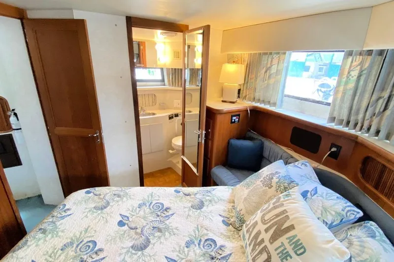 Slide: The Image of Cozy 1992 Carver 36 Aft Cabin interior with floral bedding and ensuite bathroom. - 7