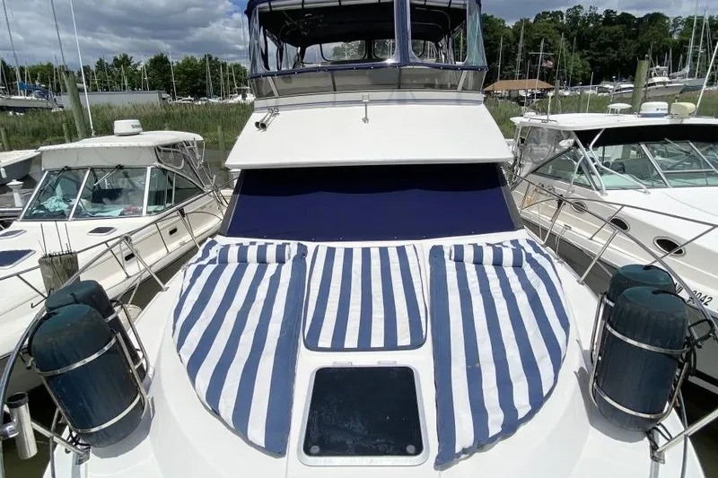 Slide: The Image of 1992 Carver 36 Aft Cabin yacht with striped sun pads, docked at marina. - 8
