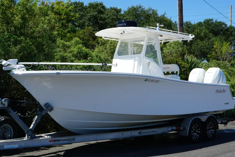 The Image of 2016 Onslow Bay 27 XS boat on trailer, surrounded by lush greenery. - 1