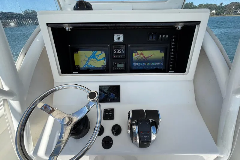 Slide: The Image of 2016 Onslow Bay 27 XS boat dashboard with navigation screens and steering wheel. - 10