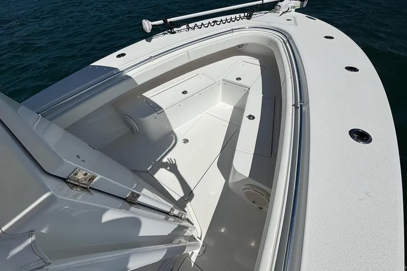 Slide: The Image of 2016 Onslow Bay 27 XS boat interior with seating and storage, on calm water. - 14