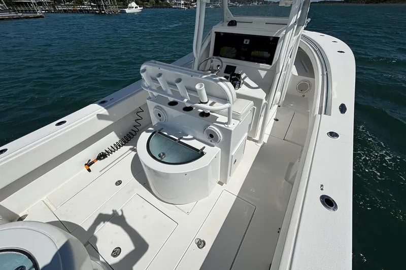 Slide: The Image of 2016 Onslow Bay 27 XS boat interior with helm and seating, on calm water. - 17