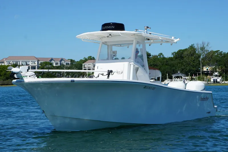 Slide: The Image of 2016 Onslow Bay 27 XS boat on water, clear sky, residential background. - 4