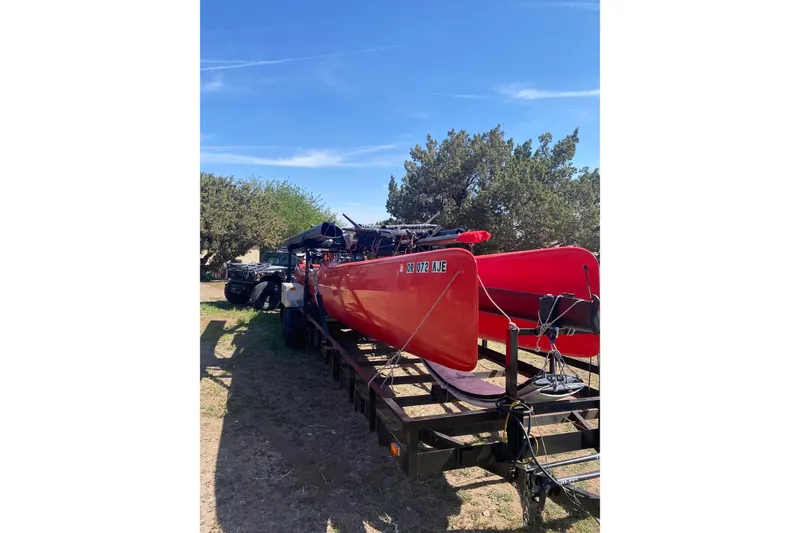 Slide: The Image of Red 2011 Marstrom MC 32 catamaran on trailer under clear blue sky. - 2