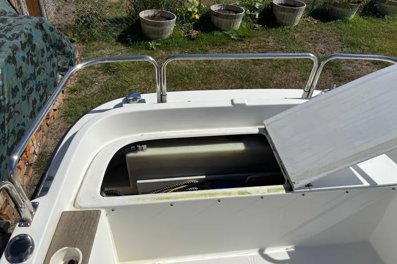 Slide: The Image of 2009 Ranger Tugs R-21 EC boat storage compartment with open hatch, outdoor setting. - 16