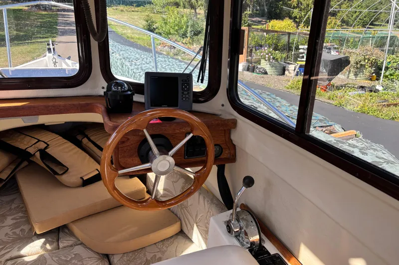 Slide: The Image of 2009 Ranger Tugs R-21 EC boat interior with wooden steering wheel and navigation equipment. - 6