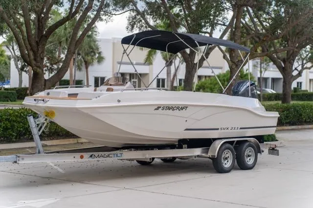 Slide: The Image of 2026 Starcraft SVX 211 OB boat on trailer, parked outdoors. - 1