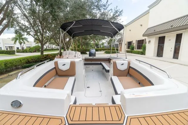 Slide: The Image of 2026 Starcraft SVX 211 OB boat with tan seating and black canopy in a driveway. - 8