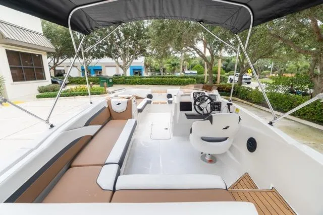 Slide: The Image of 2026 Starcraft SVX 211 OB boat interior with seating, steering console, and canopy. - 13