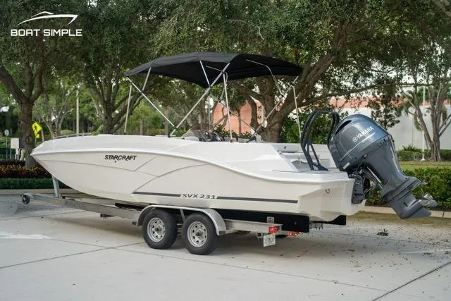 Slide: The Image of 2023 Starcraft SVX 231 OB DH boat on trailer, parked outdoors. - 3