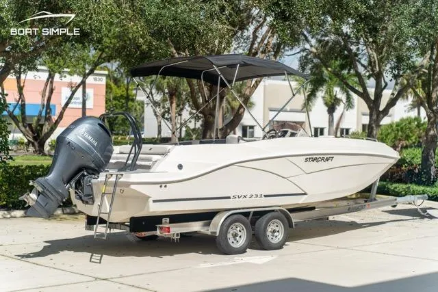 Slide: The Image of 2023 Starcraft SVX 231 OB DH boat on trailer, parked outdoors with Yamaha outboard motor. - 4