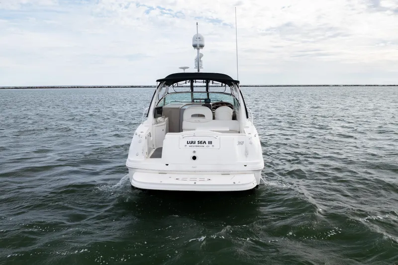 Slide: The Image of 2003 Sea Ray 360 Sundancer yacht cruising on open water, rear view. - 11