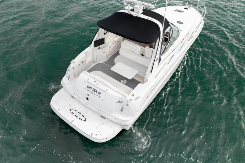 Slide: The Image of 2003 Sea Ray 360 Sundancer yacht cruising on open water, rear view. - 13