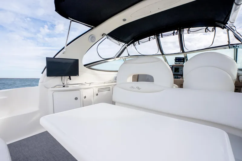 Slide: The Image of Interior of 2003 Sea Ray 360 Sundancer yacht with white seating and a mounted TV. - 16