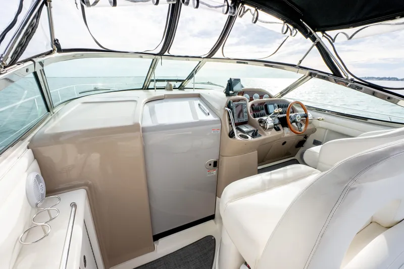 Slide: The Image of 2003 Sea Ray 360 Sundancer cockpit with modern controls and luxurious seating on open water. - 18