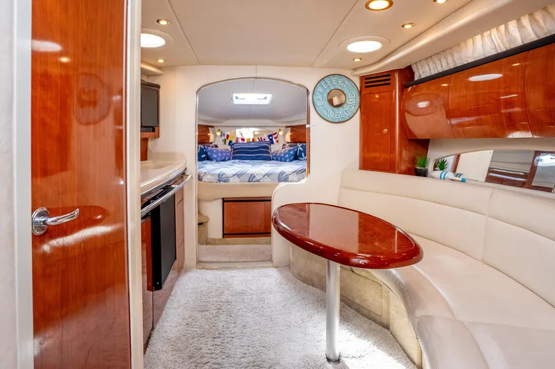 Slide: The Image of Interior of 2003 Sea Ray 360 Sundancer yacht with elegant wood finishes and cozy seating area. - 20