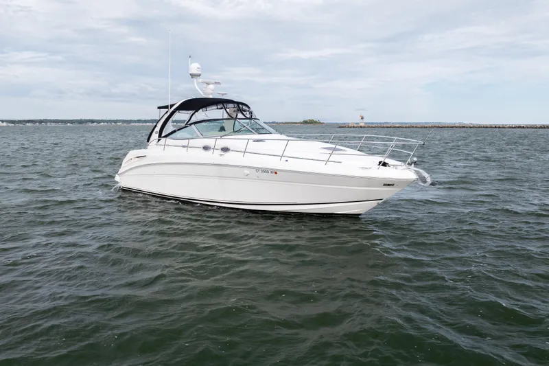 Slide: The Image of 2003 Sea Ray 360 Sundancer yacht cruising on open water under cloudy skies. - 4