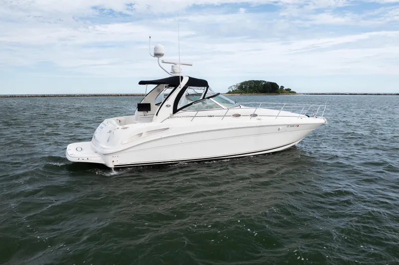 Slide: The Image of 2003 Sea Ray 360 Sundancer yacht cruising on open water under a clear sky. - 5