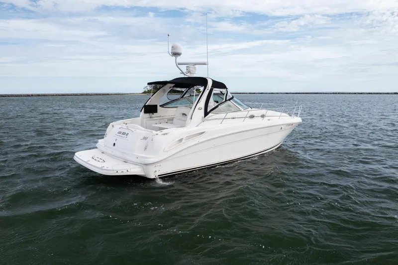 Slide: The Image of 2003 Sea Ray 360 Sundancer yacht on open water under a cloudy sky. - 6