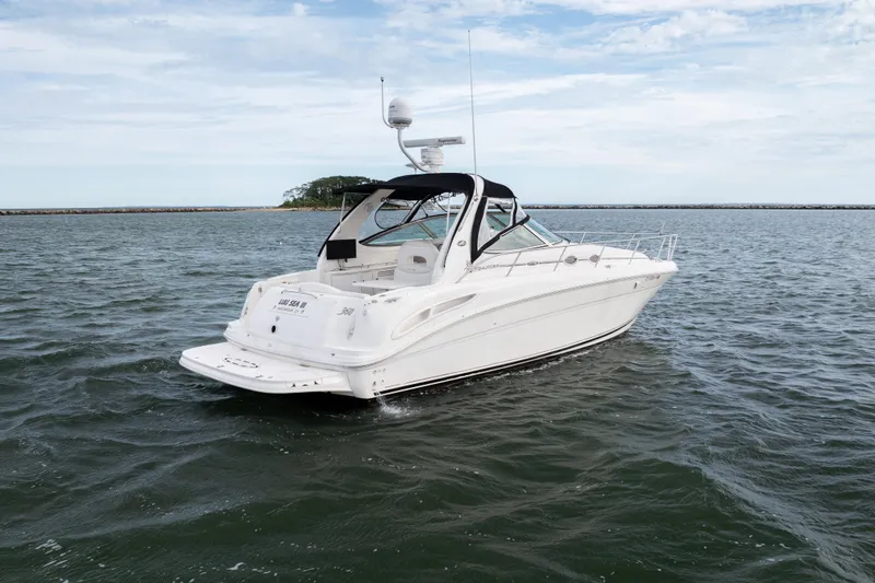 Slide: The Image of 2003 Sea Ray 360 Sundancer yacht cruising on open water under a cloudy sky. - 7