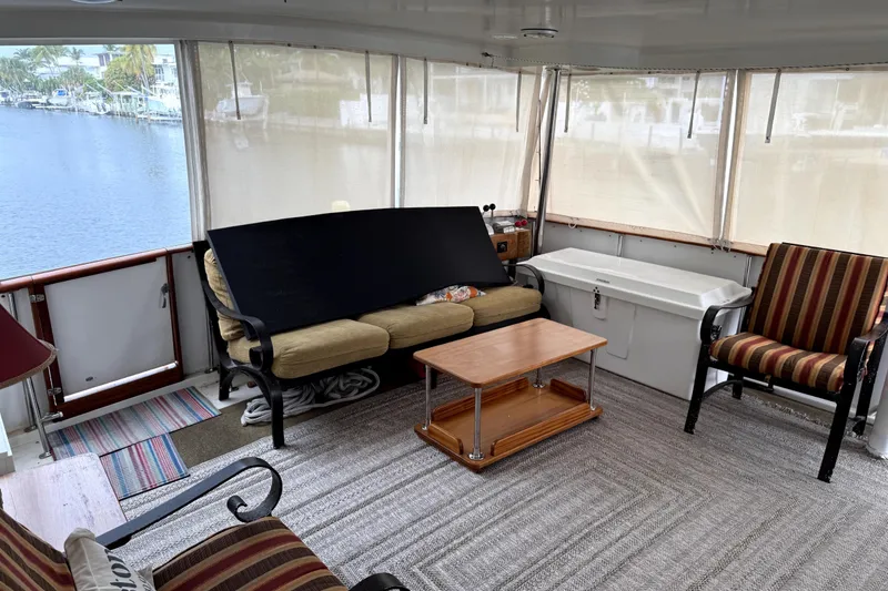 Slide: The Image of 1991 Californian 55 Cockpit Motor Yacht interior with cozy seating and waterfront view. - 11