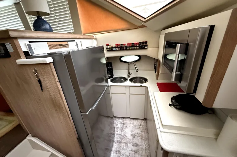 Slide: The Image of Compact kitchen in 1991 Californian 55 Cockpit Motor Yacht with modern appliances and dual sinks. - 2
