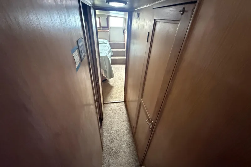 Slide: The Image of Narrow hallway inside 1991 Californian 55 Cockpit Motor Yacht, leading to a cozy bedroom. - 30
