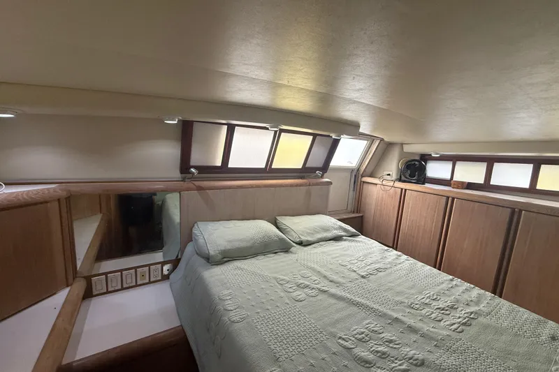 Slide: The Image of Interior of 1991 Californian 55 Cockpit Motor Yacht bedroom with bed and wooden cabinetry. - 36
