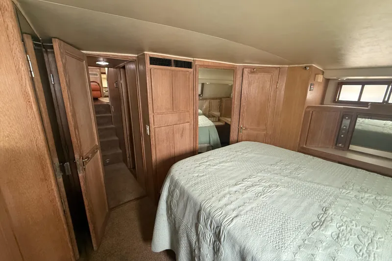 Slide: The Image of Bedroom interior of 1991 Californian 55 Cockpit Motor Yacht with wood paneling and cozy bed. - 37