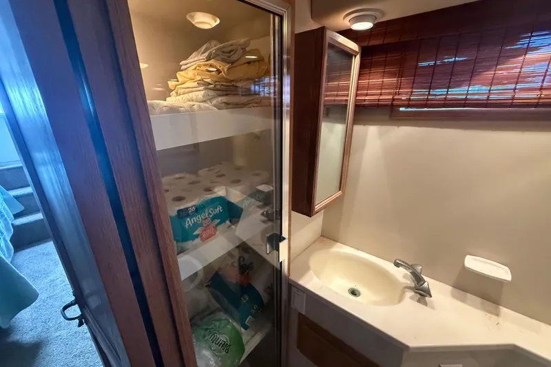 Slide: The Image of Bathroom storage in 1991 Californian 55 Cockpit Motor Yacht with towels and toiletries. - 39