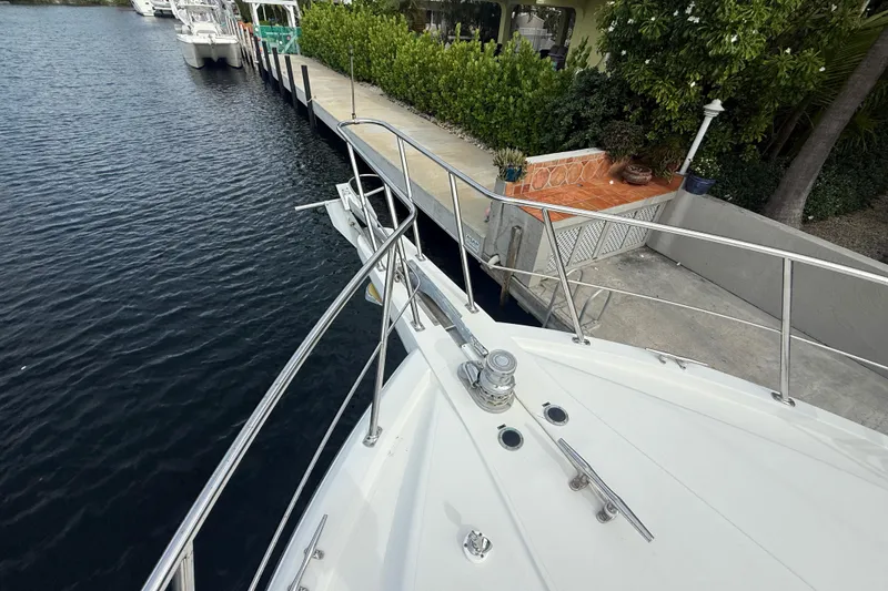 Slide: The Image of 1991 Californian 55 Cockpit Motor Yacht docked by a waterfront with lush greenery. - 43