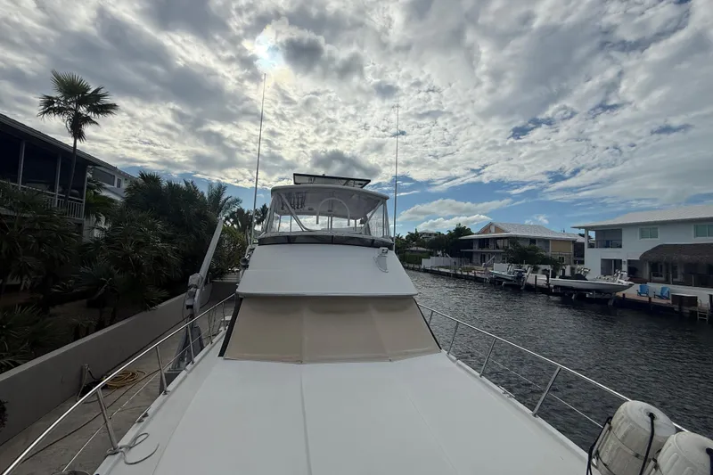Slide: The Image of 1991 Californian 55 Cockpit Motor Yacht docked by waterfront homes under cloudy sky. - 44