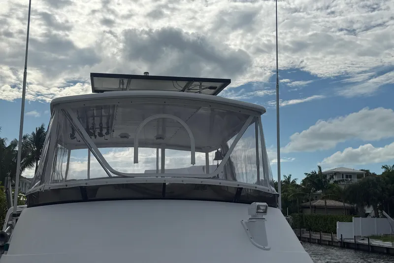 Slide: The Image of 1991 Californian 55 Cockpit Motor Yacht under cloudy sky, docked near palm trees. - 45