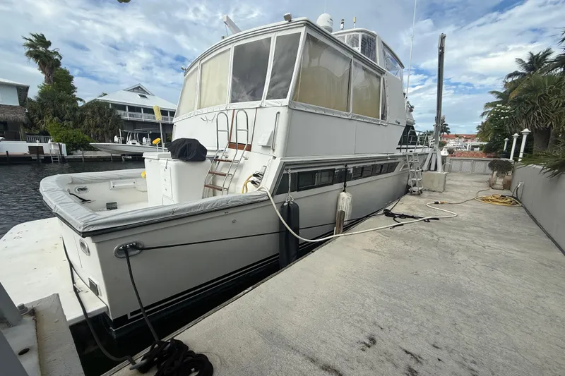 Slide: The Image of 1991 Californian 55 Cockpit Motor Yacht docked by waterfront homes. - 48