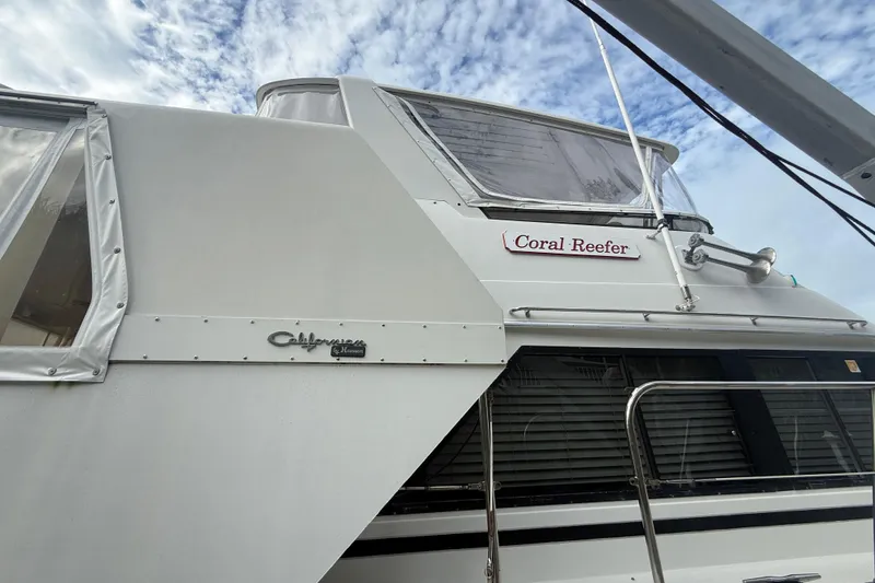 Slide: The Image of 1991 Californian 55 Cockpit Motor Yacht, "Coral Reefer," side view under cloudy sky. - 49