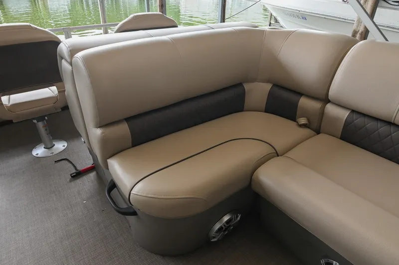 Slide: The Image of 2023 SUNTRACKER DLX 22 Sportfish boat interior with beige cushioned seating. - 12