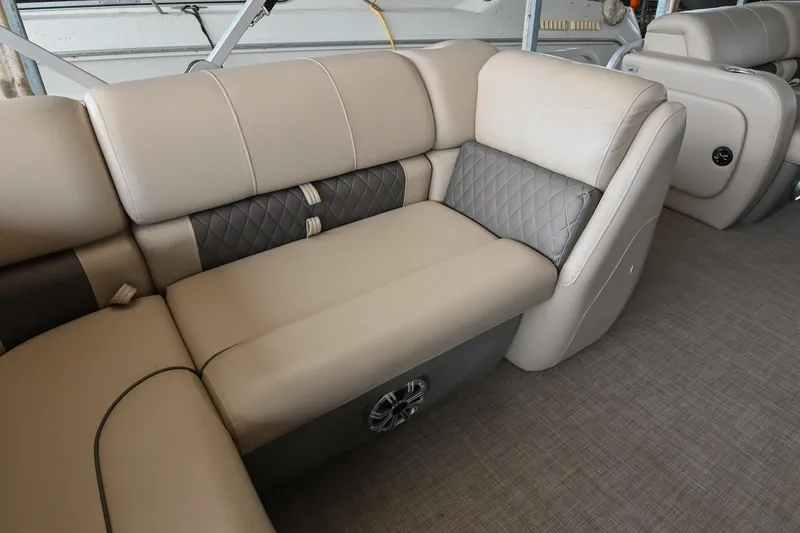 Slide: The Image of 2023 SUNTRACKER DLX 22 Sportfish interior with beige and gray cushioned seating. - 13