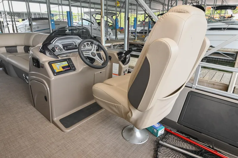 Slide: The Image of 2023 SUNTRACKER DLX 22 Sportfish boat interior with captain's chair and control panel. - 14